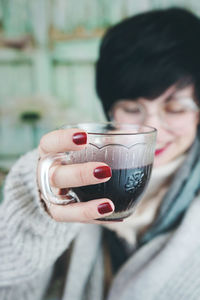Close-up of mid adult woman drinking coffee at home