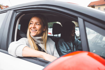 Portrait of smiling young woman sitting in car