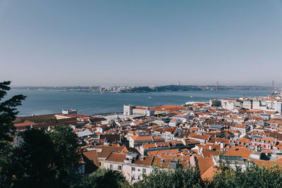 High angle view of townscape by sea against clear sky