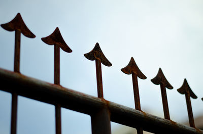 Low angle view of rusty metallic railing against clear sky