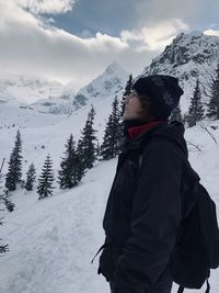 Woman standing on snowcapped mountains during winter