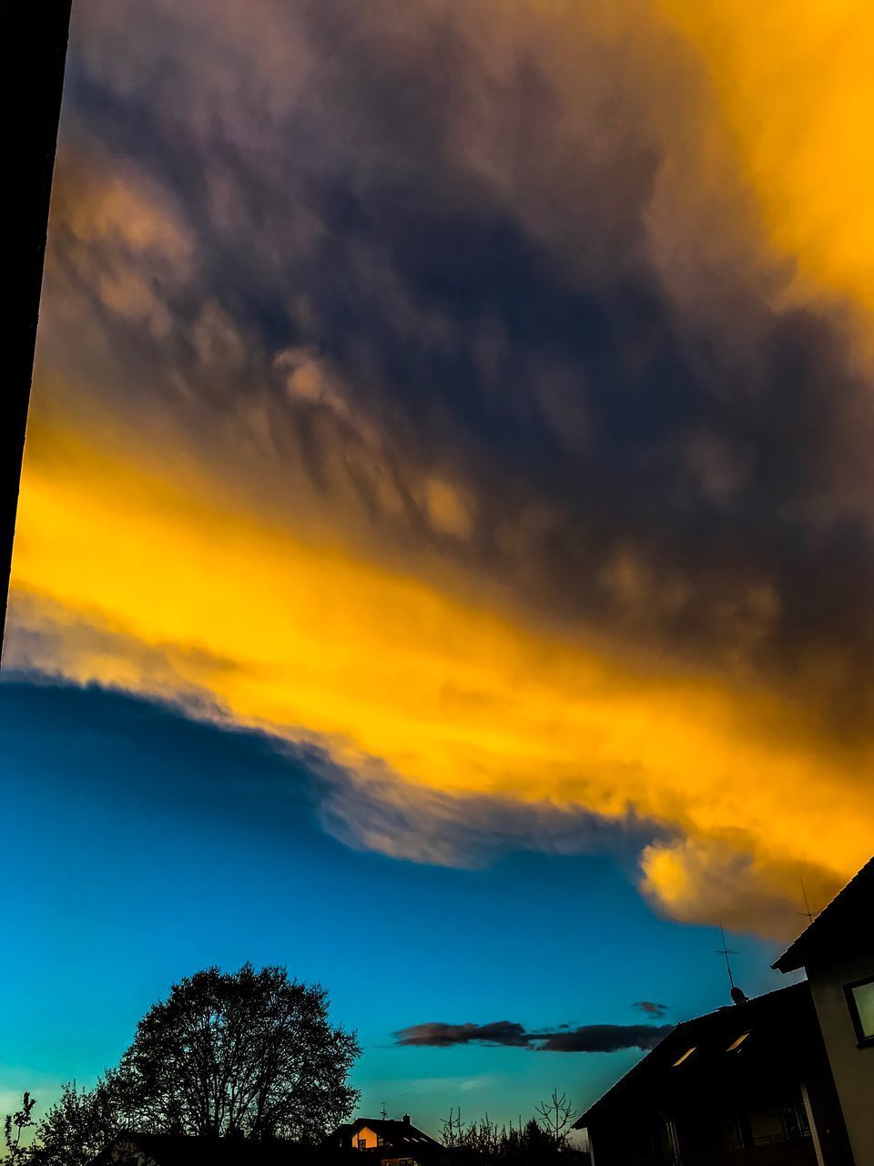 LOW ANGLE VIEW OF DRAMATIC SKY OVER SILHOUETTE TREES