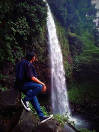 Full length of waterfall on rocks in forest