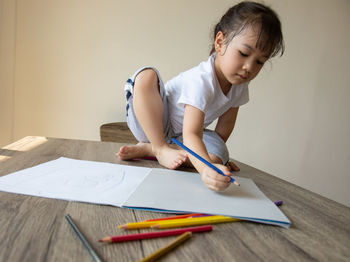 Cute girl wearing mask on table