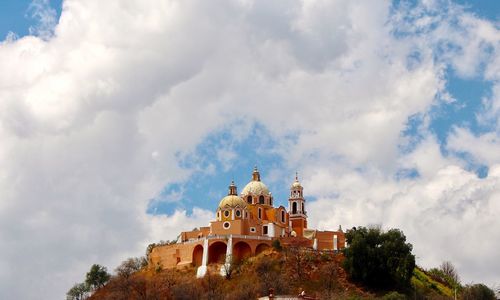 Low angle view of church against cloudy sky