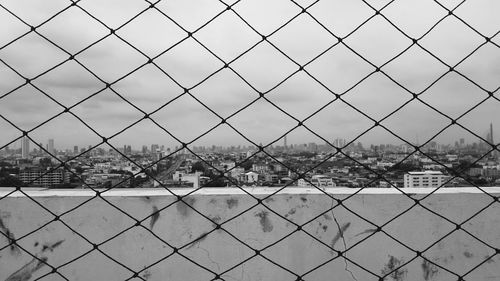 Scenic view of river seen through chainlink fence