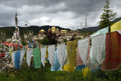 Clothes drying on clothesline against sky in city