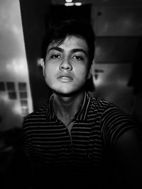 Portrait of young man standing at home