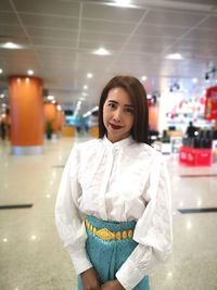 Portrait of smiling woman standing in shopping mall