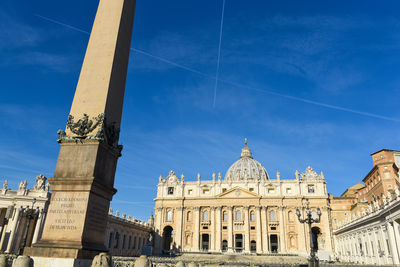 Low angle view of st peter basilica and obelisk against blue sky