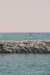 Scenic view of rocks in sea against clear sky