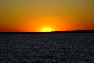 Scenic view of sea against orange sky