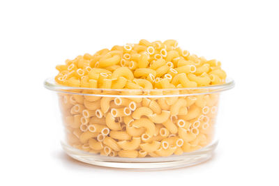 Close-up of red chili peppers in bowl against white background