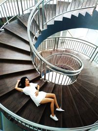 High angle view of woman lying on spiral staircase