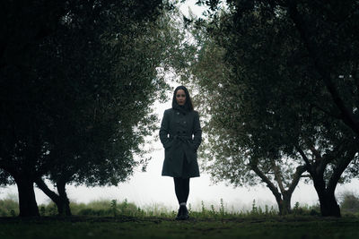 Low-angle view of woman standing in forest