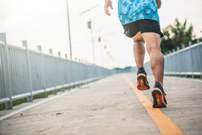 Low section of man walking on bridge