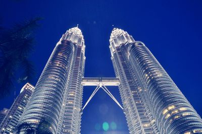 Low angle view of illuminated buildings against blue sky