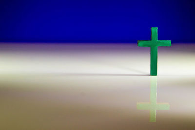 Close-up of cross against blue sky