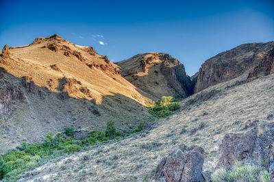 Scenic view of mountains against clear blue sky