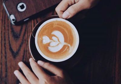 Cropped image of hand holding coffee cup