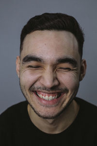 Close-up of happy young man against wall