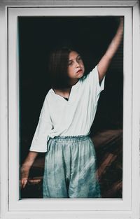 Young woman looking through window