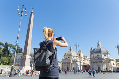 People in front of historical building against clear sky