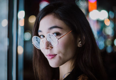 Close-up portrait of young woman drinking outdoors