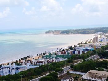High angle view of cityscape by sea against sky