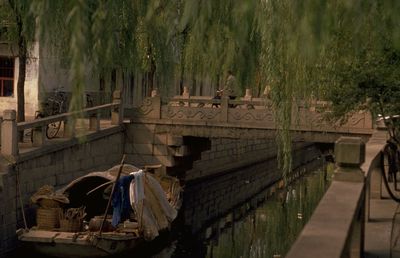 Boat in canal against footbridge