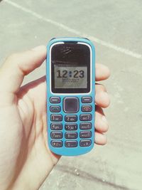 Cropped hand of person holding vintage mobile phone