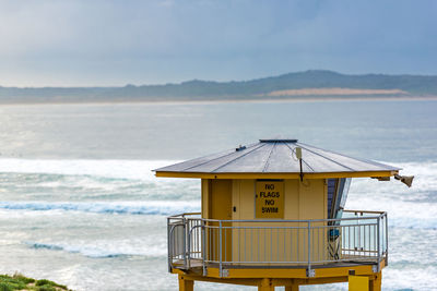 Hut on beach against sky