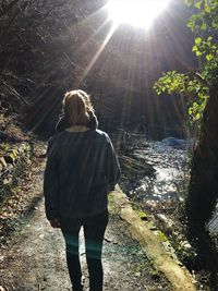 Rear view of woman standing on sunny day