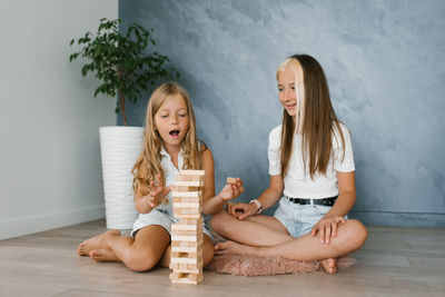 Caucasian sisters, the family spends time together on vacation in the living room of the house