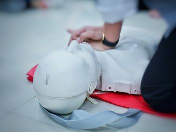 Midsection of person with cpr dummy during training