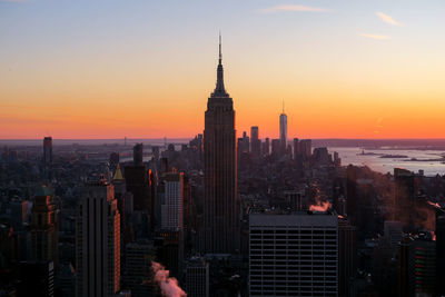 Skyscrapers in city at sunset