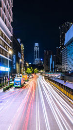 Light trails on city street by buildings at night