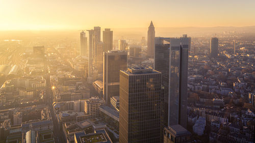 Aerial view of illuminated buildings in city during sunset