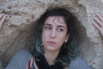 Close-up of beautiful woman standing by rock