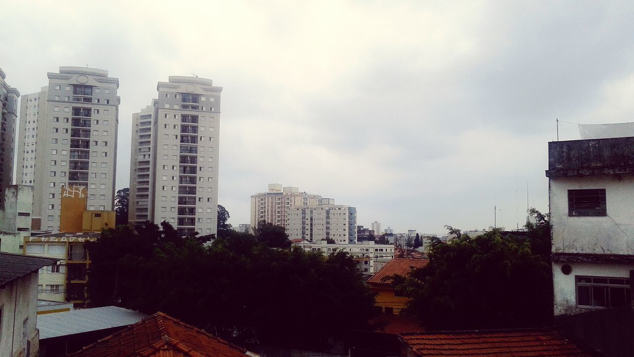 LOW ANGLE VIEW OF RESIDENTIAL BUILDINGS AGAINST CLOUDY SKY