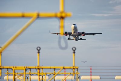 Low angle view of airplane flying against sky