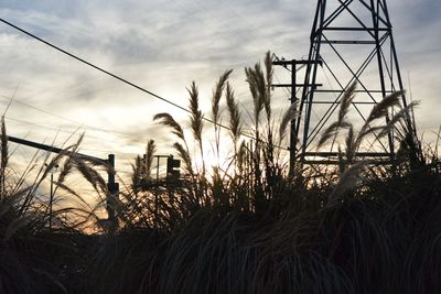 Electricity pylon against sky during sunset