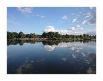 Scenic view of lake against cloudy sky