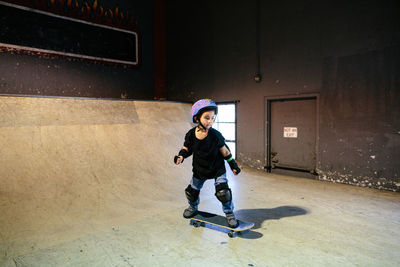 Focused skateboarding boy at an indoor skatepark