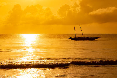 Silhouette sailboat in sea against sky during sunset