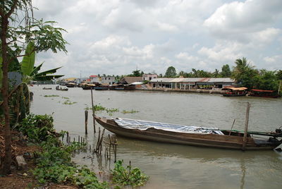 Boats moored at shore against sky