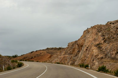 Road by mountain against sky