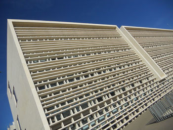 Low angle view of modern building against clear blue sky