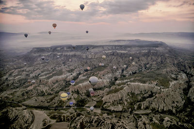 Hot air balloons flying over landscape against sky