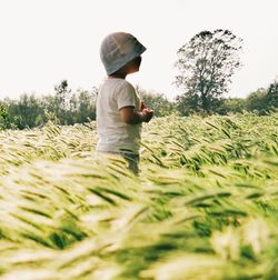 Rear view of man standing on grassy field